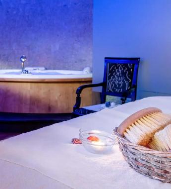 Spa with hot tub, bed, and basket of brushes.