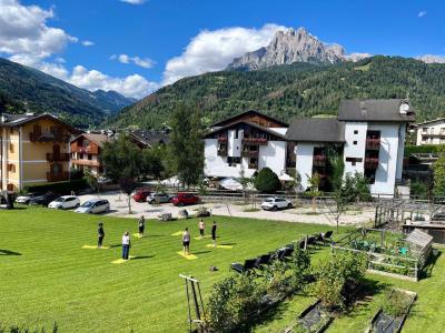 Yoga all'aperto tra montagne e cielo azzurro, serenità e natura.