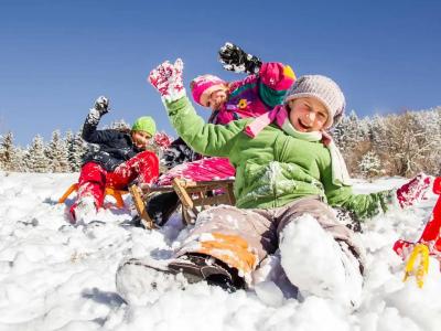Children playing in the snow with sleds, having fun on a winter day.