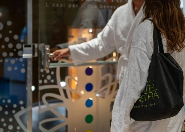 Due persone in accappatoio aprono una porta, atmosfera di relax e benessere.