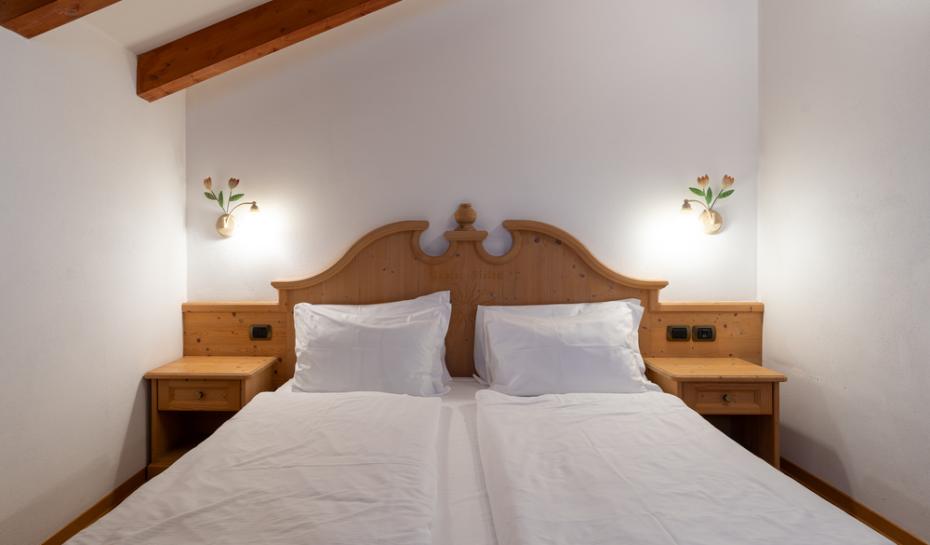 Camera accogliente con letto matrimoniale e luci soffuse in legno.