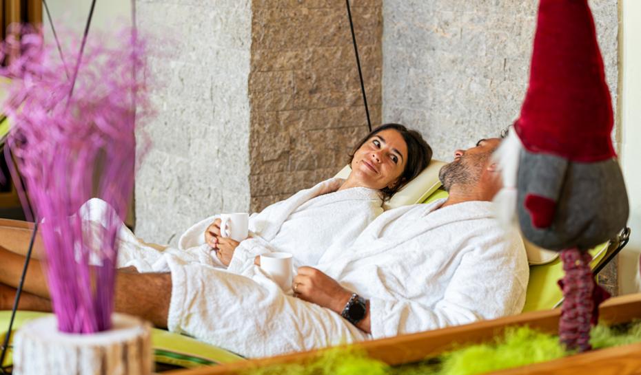 Area relax con lettini, bevande e frutta fresca, ambiente accogliente e luminoso.